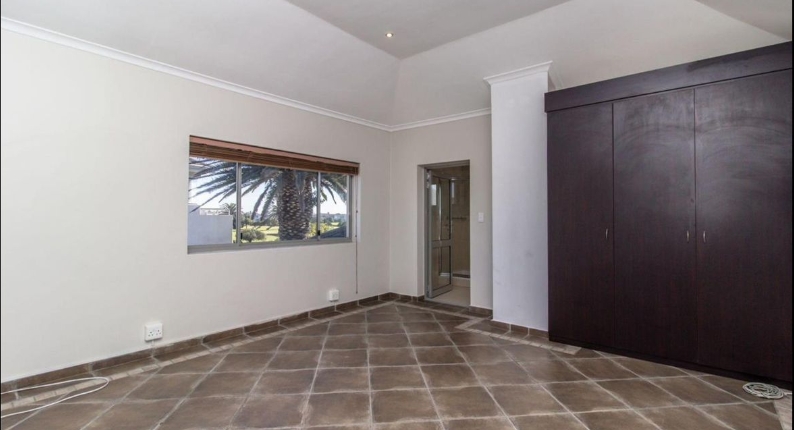 Bedroom before renovation with dark cupboards and tiled floor