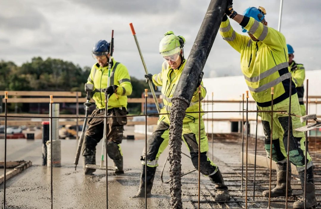 Workers pouring concrete on a reinforced slab
